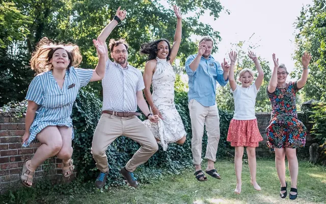 Family jumping joyfully in a garden